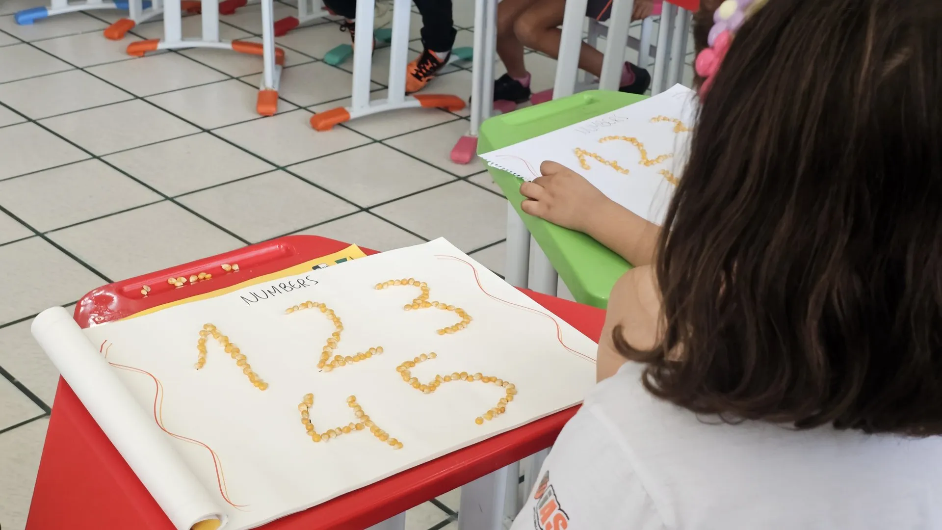 Professora ensinando inglês para crianças em formato retangular